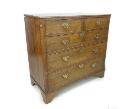 A George III oak chest of two short over three long graduating drawers, with brass plate handles and cock beading, raised on 