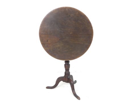 A George III mahogany tilt top occasional table, the circular surface raised on a turned support and tripod base, 64 by 64 by