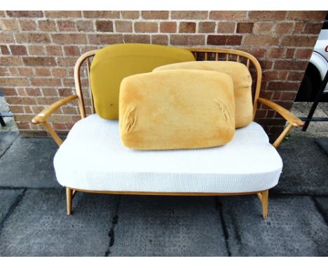 A LIGHT ERCOL TWO-SEATER STICK-BACK SOFA  131cm wide 67cm deep 80cm high