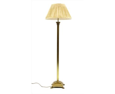 A brass Corinthian column standard lamp , with acanthus leaf capital over a reeded column over a stepped square base on paw f