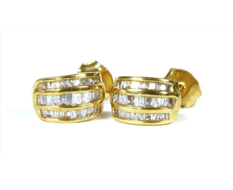 A pair of silver gilt diamond stud earrings, of curved form with three rows of tapered baguette cut diamonds, channel set, to