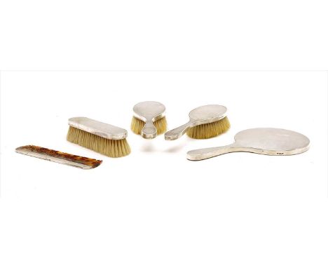 A five piece silver backed brush set , with engine turned decoration