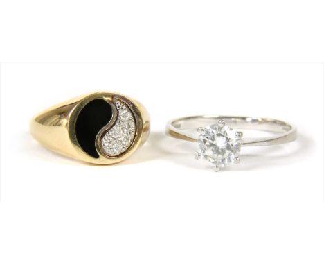 A gold diamond and enamel yin and yang ring, the yang half grain set with brilliant cut diamonds, with black enamel to the yi