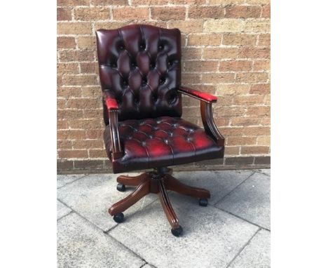 RED LEATHER ADJUSTABLE BUTTON BACK SWIVEL CHAIR, raised on central column out swept lets with casters