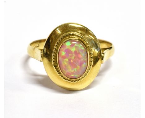 AN OPAL SINGLE STONE 14CT GOLD RING The oval cabochon cut opal 8mm x 6 mm bezel set to oval head and a 14ct gold shank stampe