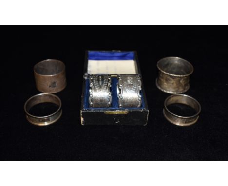 A QUANTITY OF SIX SILVER NAPKIN RINGS comprising a boxed pair with engraved initials, a pair of engine turned and two others,