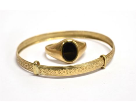 TWO ITEMS OF 9CT GOLD JEWELLERY  comprising a small onyx set signet ring, size K ½ and a baby bangle with patterned finish, t