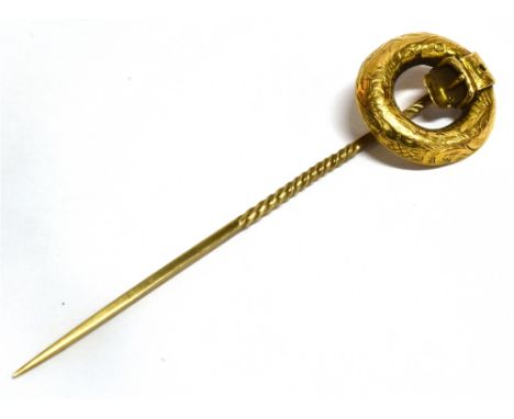A VICTORIAN YELLOW METAL STICK PIN The top comprising a circular belt design with a barley twist thread pin, unmarked, assess