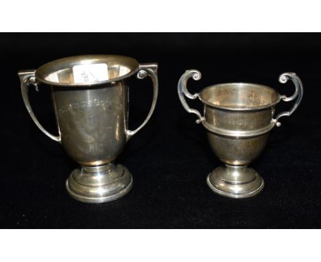 TWO SMALL SILVER TROPHY CUPS Tallest 8cms, total silver weight approx. 96.3 grams Condition Report : heavy dents to one, wear