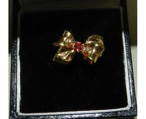 A 14ct gold ruby and diamond stylised bow ring.