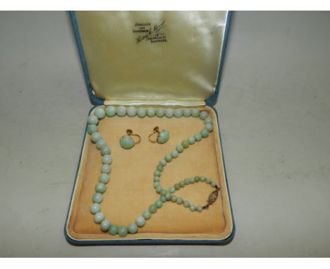 A graduated jade bead necklace, the yellow metal clasp stamped '9ct', together with a pair of cabochon jade earrings.
