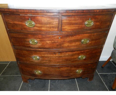 A George III mahogany bow front chest of two short over three long cock beaded drawers raised on shaped bracket feet.