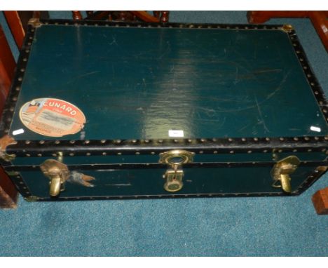 An early 20th century cabin trunk with Cunard line stateroom baggage sticker to the lid.