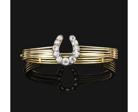 A Victorian diamond-set horseshoe bangle, set with graduated old circular and cushion-shaped diamonds on a five row gold bang