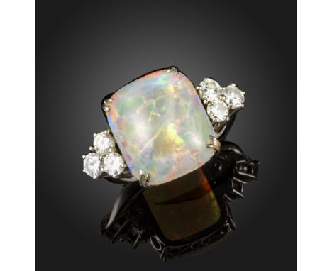 An opal and diamond ring, the square cabochon white opal is flanked with clusters of round brilliant-cut diamonds in white go