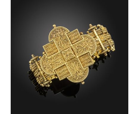 An Etruscan revival gold bangle, the quatrefoil plaque with pellet and filigree decoration on a three row gold bracelet decor