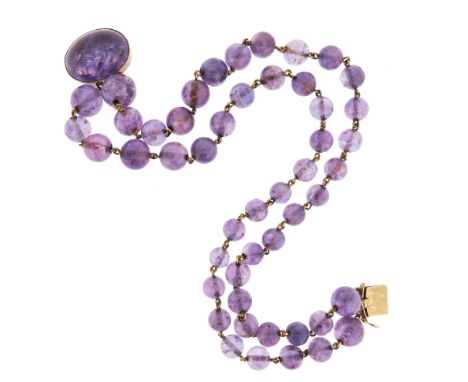 A two row slightly graduated amethyst bead necklace, the gold clasp mounted with a larger oval shape amethyst cabochon, 40cm