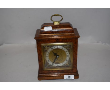 A modern John Walker Elliott bracket clock having a Walnut burr veneer case.