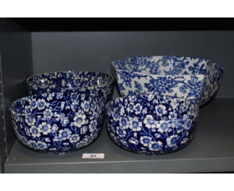 Four vintage ceramic bowls having full chintz floral patterns. One having repair