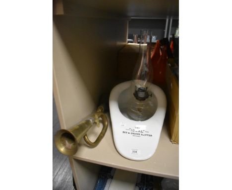 An ideal bed and douche slipper with a brass horn and clear glass oil burning lamp.