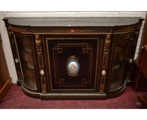 A VICTORIAN EBONISED AND MARQUETRY INLAID CREDENZA, with ornate brass mountsand porcelain panels. Centre panel door with an o