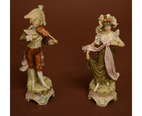 A PAIR OF ROYAL DUX PORCELAIN FIGURES. One depicting a man playing a violin and theother a woman in long flowing gown listeni
