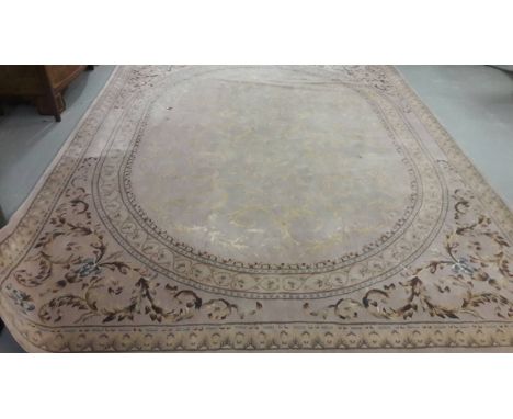 A FINE QUALITY HEAVY WOOL RUG. In the French style, light grey field with all-over leafsprays within an oval panel with leafy