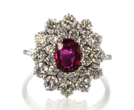 A ruby and diamond cluster dress ring designed as a central ruby of approximately 1.00ct surrounded by two concentric cluster