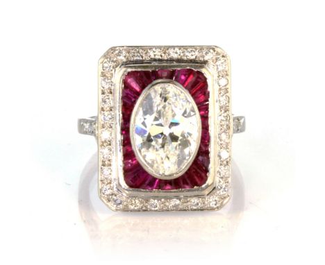 An antique French Art Deco diamond and ruby dress ring in platinum, set with a large, old mine oval cut diamond of approximat