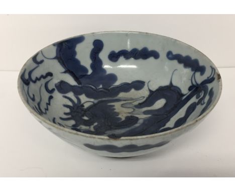 A  blue and white bowl:Ming Dynasty, with a lively decoration of a clawed dragon body to the exterior and a dragon head with 