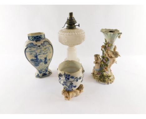 A Victorian milk glass oil lamp base, a Delft vase, continental late 19thC porcelain candelabrum base decorated with cherubs 