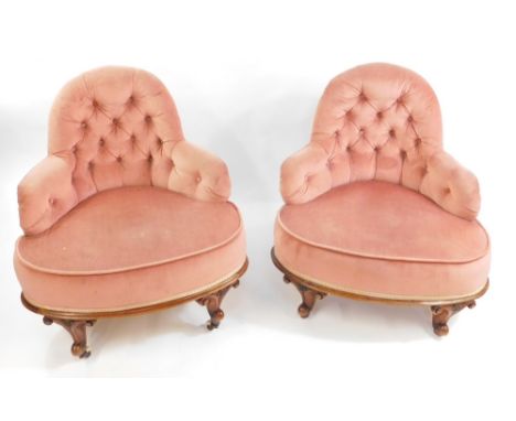 A pair of Victorian walnut conversation seats, upholstered in button back pink dralon, raised on carved scrolling legs, cappe