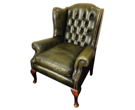 A green leather Chesterfield style wingback armchair, with button back and stud detailed arms, 100cm high, 80cm wide, 80cm de
