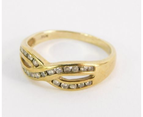 A dress ring, formed with two links crossed over, set with tiny diamonds, in a yellow metal setting, stamped 10kt, size O½, 2