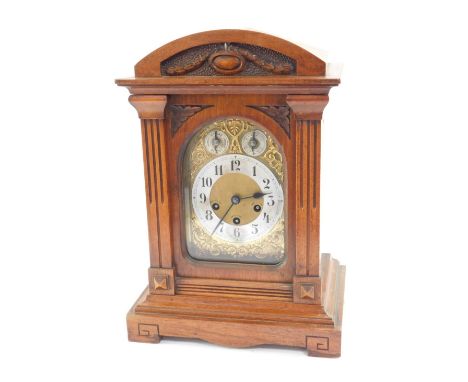 A late 19thC Junghans walnut cased mantel clock, the arched brass dial with scroll spandrels, silvered chapter ring bearing A