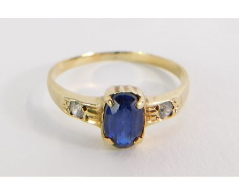 A sapphire and diamond set dress ring, the rectangular cut sapphire in four claw rub over setting, with two tiny diamond set 