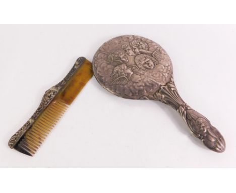 A George V silver dressing table set, comprising a silver backed hand mirror embossed with five cherub's heads, Birmingham 19