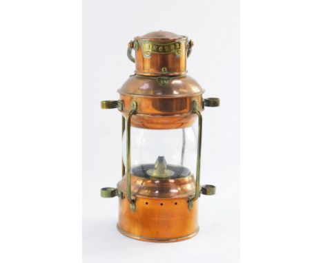 An early 20thC copper and brass anchor ship's lamp, with carrying handle, and anchor plaque, 33cm high.