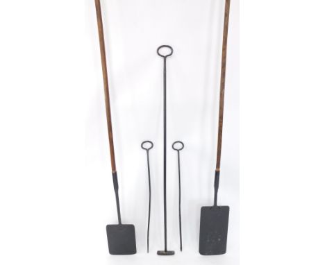 A group of baking tools, wrought iron rake, two baker's oven pokers, and two baker's peels on wooden handles. (5)