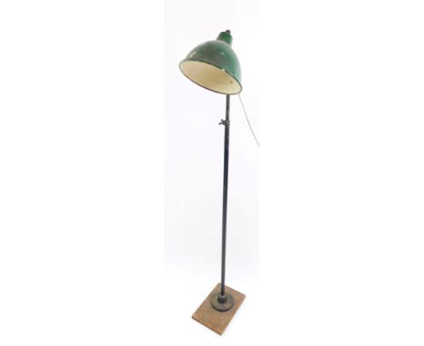 An industrial mid century anglepoise type standard lamp, the domed green metal shade, on iron circular supports, attached to 