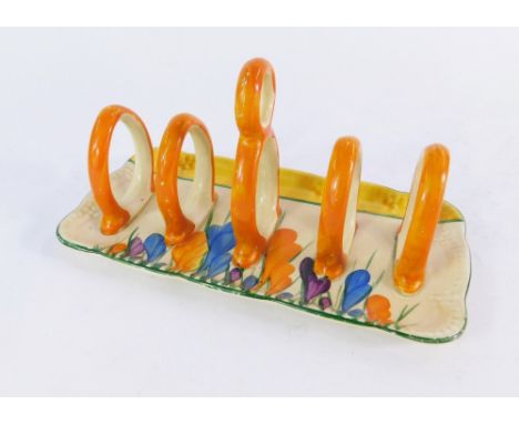 A Clarice Cliff Bizarre four division toast rack decorated in the Autumn Crocus pattern, 9cm high, 18cm wide.