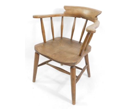 A Victorian oak and elm smoker's bow chair, with solid saddle seat, raised on turned legs, united by a double H frame stretch