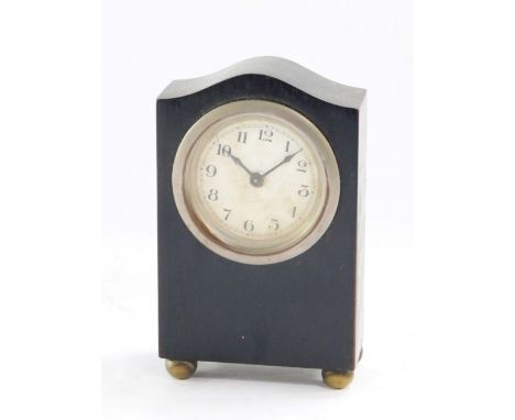 An Art Deco desk clock, the ebony frame with a steel set dial on white finish, with bun feet, 12cm high, 7.5cm wide, 4cm deep