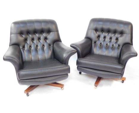 A pair of G-Plan mid century black vinyl swivel chairs, each on a wooden base with castors, with button back and detailing, 8