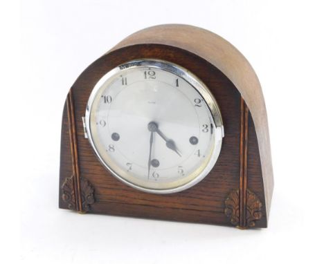 An Art Deco Enfield oak cased mantel clock, the silvered circular dial bearing Arabic numerals, eight day movement with Westm