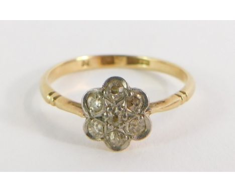 A 18ct gold and platinum daisy dress ring, the daisy set with tiny diamonds in a platinum setting in V splayed and ribbed sho