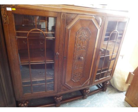 A good quality heavy oak display cabinet with two glazed sections surrounding a central carved section, approx size 142cm (h)