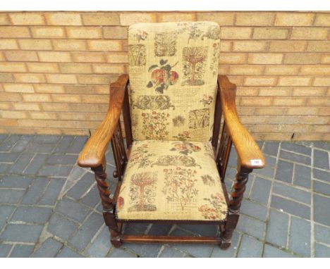 An oak framed arm chair with tapestry upholstery