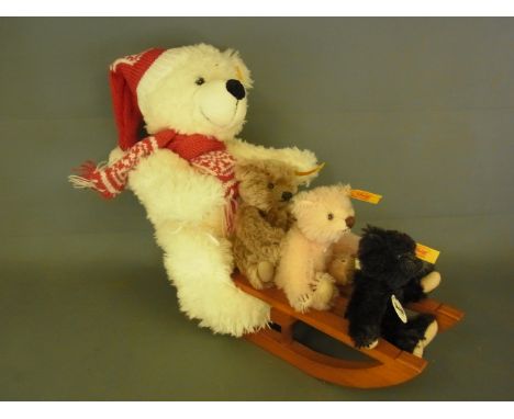 Four Steiff Teddy Bears, one large on sled and three miniatures