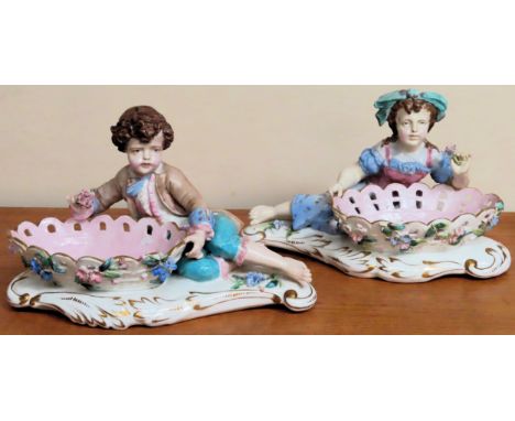Pair of hand painted and gilded ceramic reclining figure form sweet dishes

appear in reasonable used condition WITH FEW MINO
